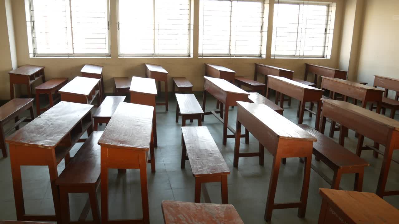 Aula vuota con scrivanie e panchine di legno