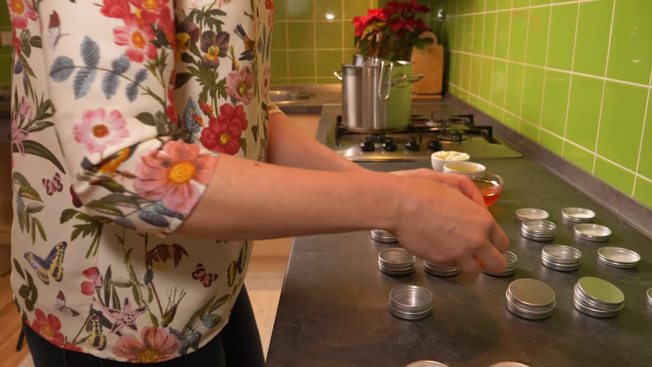 부엌에서 작은 알루미늄 용기를 여는 젊은 백인 여성의 클로즈업 샷