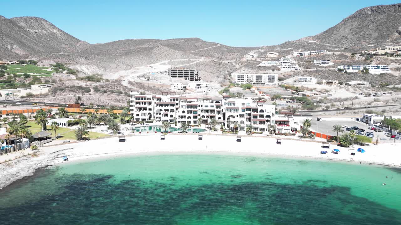 Beachfront resort at Playa Caymancito, calm sea, sunny day in La Paz, Mexico