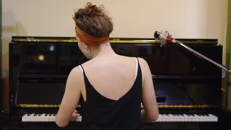 a musician playing the piano, viewed from behind