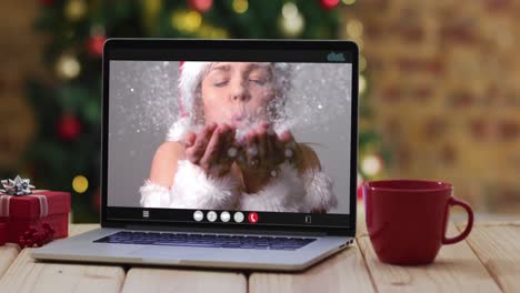 Happy-caucasian-woman-in-santa-costume-on-video-call-on-laptop,-with-christmas-decorations-and-tree