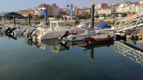 embarcaciones de recreo amarradas en el muelle del puerto con acceso por la rampa a la plataforma en una tranquila y soleada mañana de verano, tiro girando a la izquierda