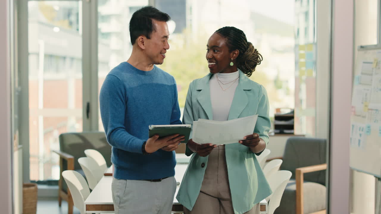 Diverse Business Colleagues Discussing Documents and Tablet in Modern Office