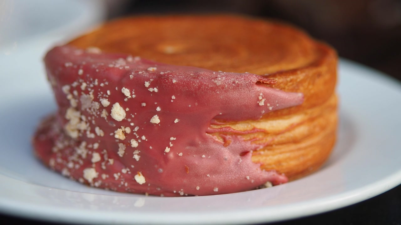 Close-up of a Pink Iced Croissant on a White Plate