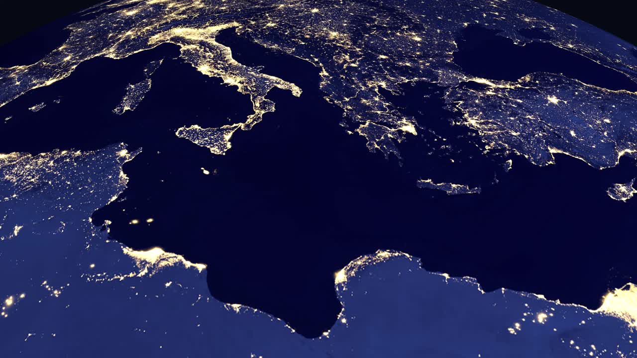 A digital earth rotates and zooms into the Mediterranean region showing city lights and labels