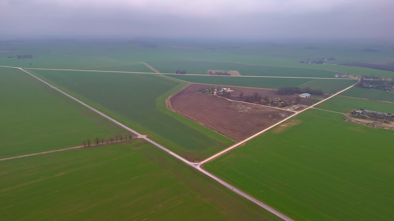 Fly over aerial view of a green rural area on a misty day