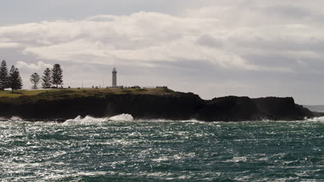 lapso de tiempo de un faro con nubes moviéndose a través del cielo mientras el océano se lava alrededor de las rocas debajo
