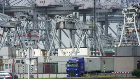 rotterdam port cranes and containers in overcast industrial scene