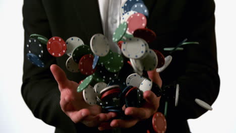 man in suit catching falling casino chips