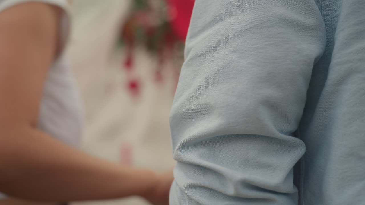 rooftop date woman guides man into heartdraped canopy, tender hand on back, soft sunset light, urban skyline backdrop, casual blue shirt, flowing fabric and hanging hearts create intimate atmosphere