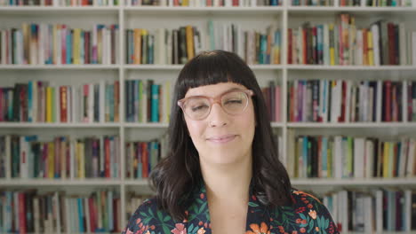 retrato de una mujer joven estudiante sonriendo estantería biblioteca universidad