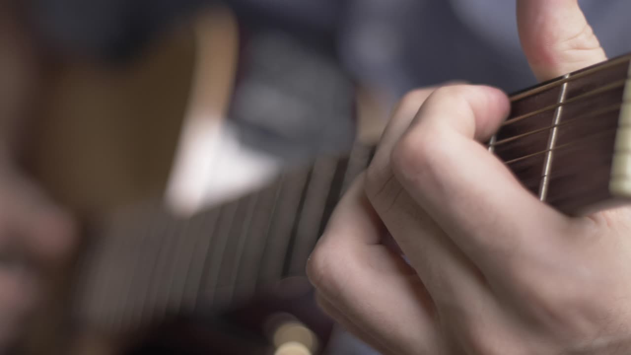 Close-up of a Man's Hands Playing Acoustic Guitar