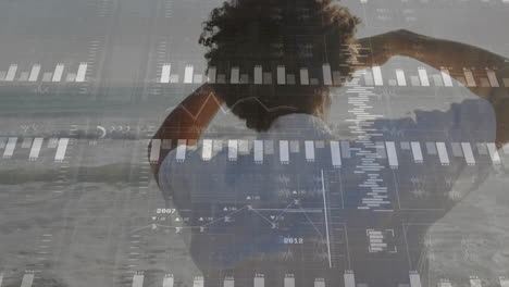 gráficos de datos financieros animados sobre una persona de pie en la playa