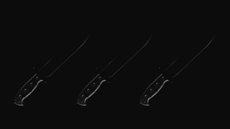 Knives on the dark background and in blinking light rotate in slowmotion