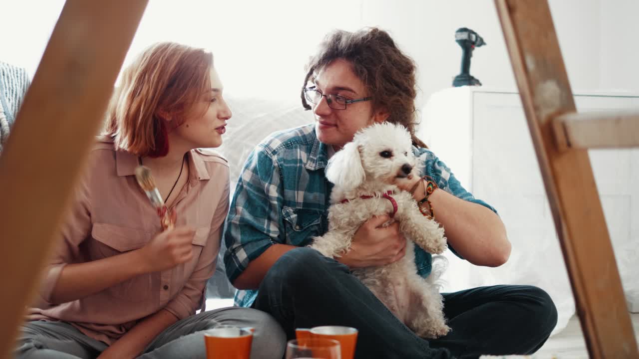 지친 부부는 사다리 앞에 바닥에 앉아서 집에서 페인팅과 봄 식사를 한 후 이야기합니다.