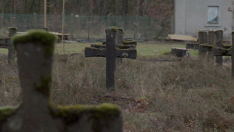 long pan over old gravestones in weed overgrown cemetery