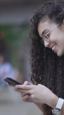 una mujer joven enviando mensajes de texto en su teléfono inteligente.