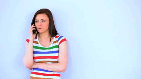 una mujer morena hablando por teléfono.