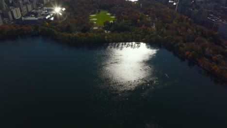 Vista-Aérea-Del-Depósito-De-Agua-Y-árboles-De-Color-Otoñal-En-El-Parque-Central-Rodeado-Por-El-Desarrollo-De-La-Ciudad.-Manhattan,-Ciudad-De-Nueva-York,-Estados-Unidos