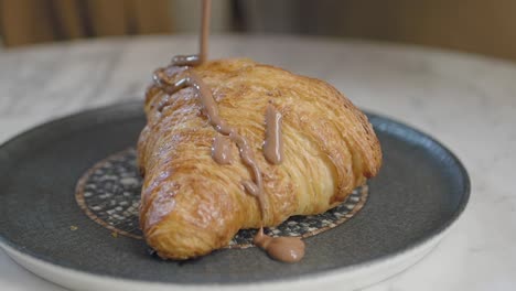 closeup of a chocolate drizzled croissant