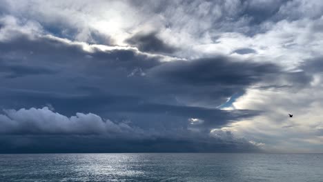 Mittelmeerstrand-Mit-Ruhigem-Wasser,-Grobem-Sand-Und-Einem-Sturm-Im-Hintergrund-Dunkelgrauer-Schwarzer-Himmel
