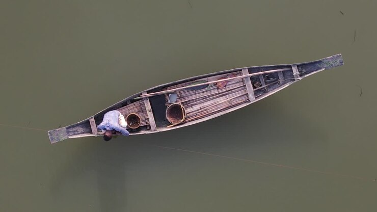 Vista aerea dall'alto di un pescatore su una barca di legno a Bholaganj, Bangladesh