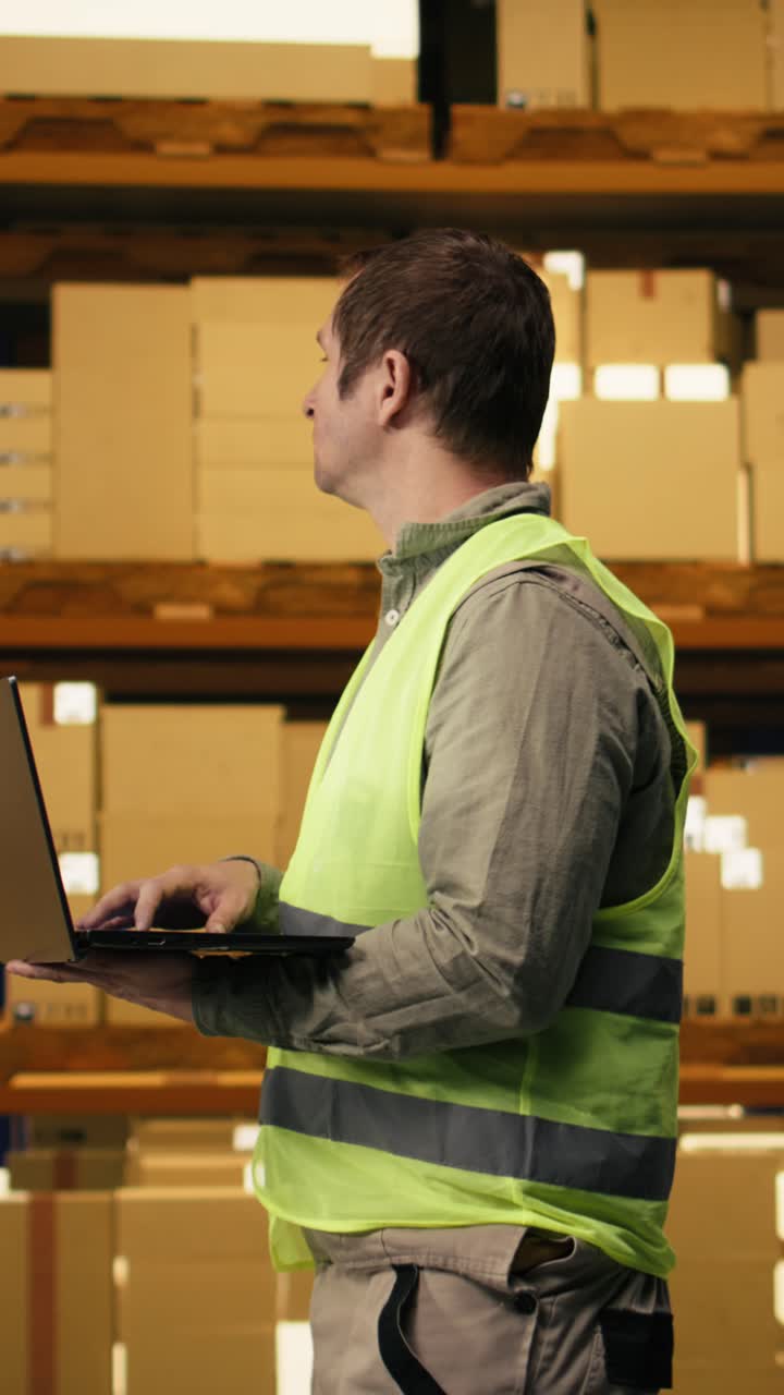 Video Verticale: Lavoratore professionista che esamina i dati di inventario in un magazzino di distribuzione.