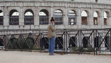 woman using phone at the colosseum in rome