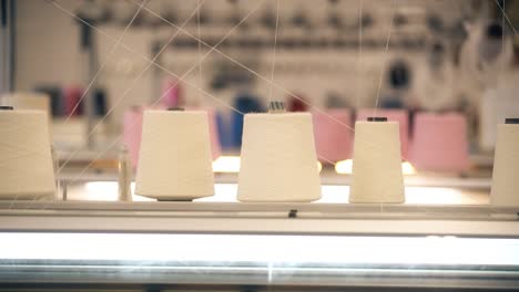 video of spools of white thread on knitting device