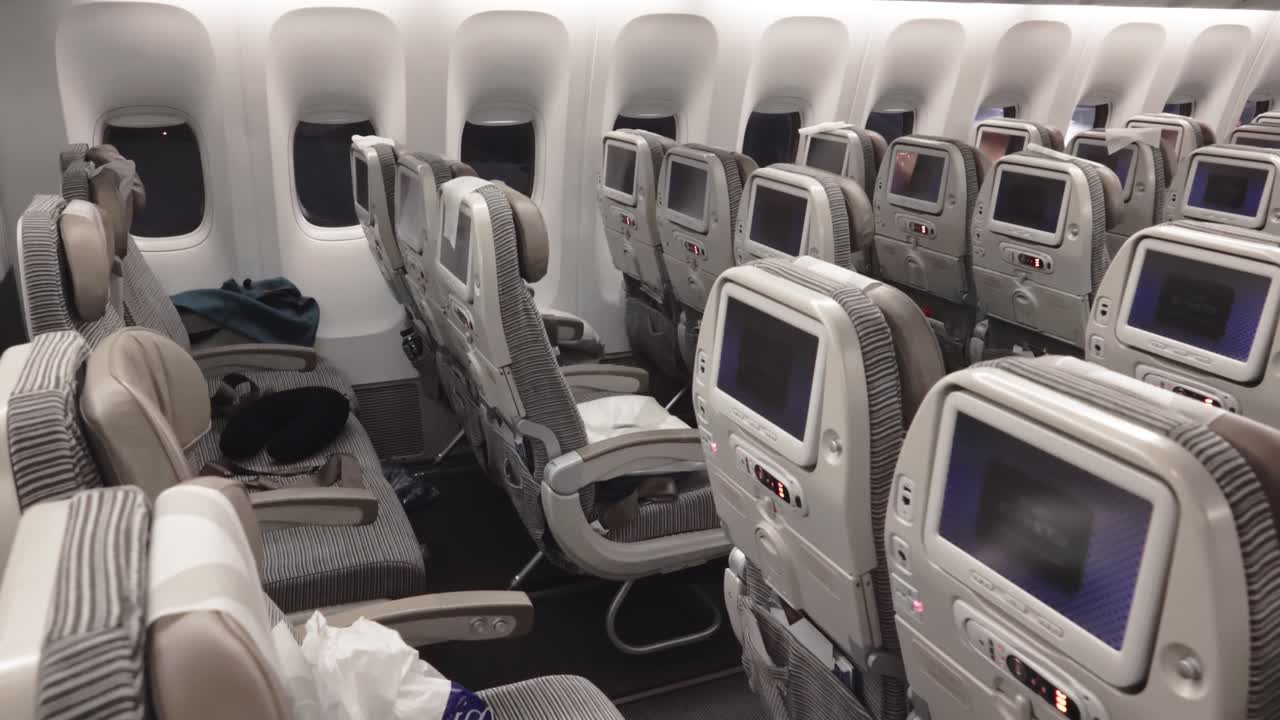 cabina de avión comercial con filas de asientos vacías