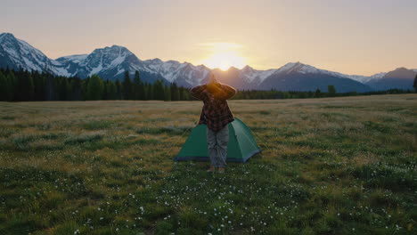 man camping in the mountains at sunrise