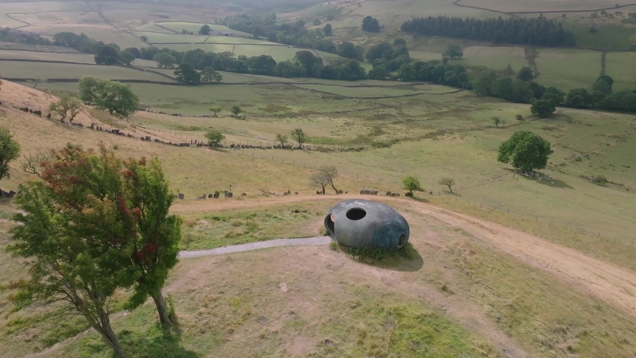 The Atom Panopticon, Wycoller, Pendle, Lancashire, Regno Unito. Ripresa in lenta discesa che rivela la valle e le colline distanti mentre le ombre delle nuvole si muovono sulla valle.