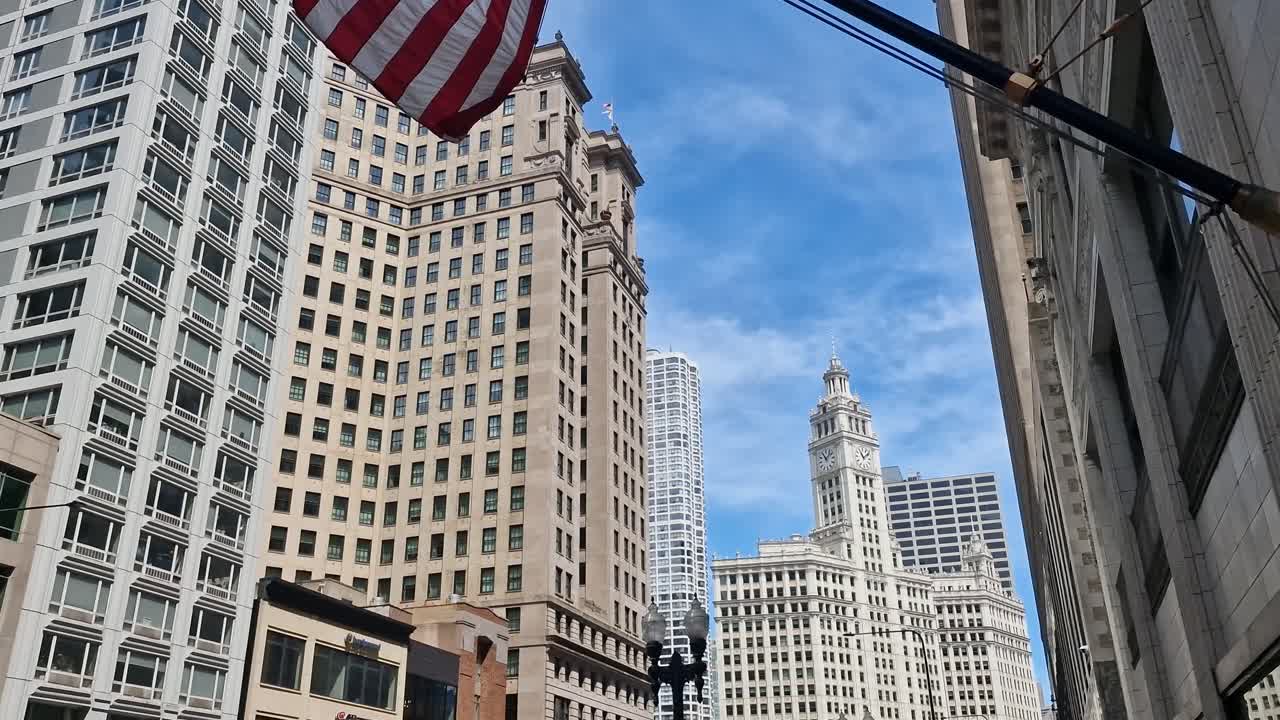 American Flag Waving on Pole Under Downtown Skyscrapers and Buildings of Chicago, Illinois USA
