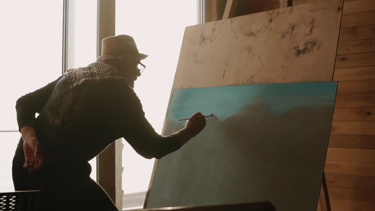 artista senior pintando en un estudio