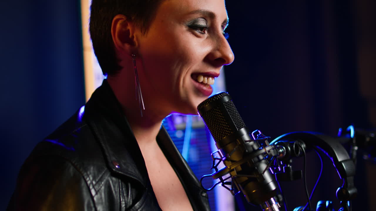 mujer cantando en el micrófono en el estudio de grabación