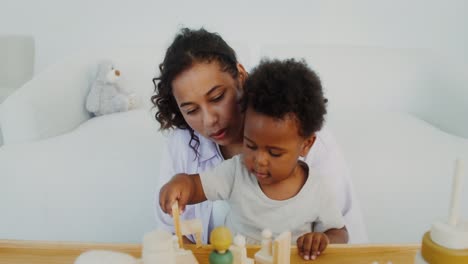 madre e hijo jugando con juguetes de madera
