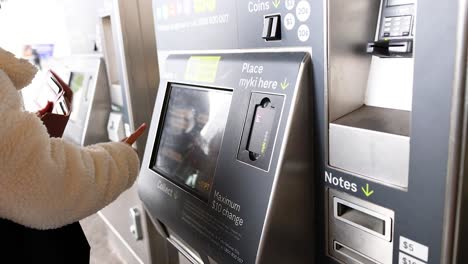 person interacting with a ticket machine