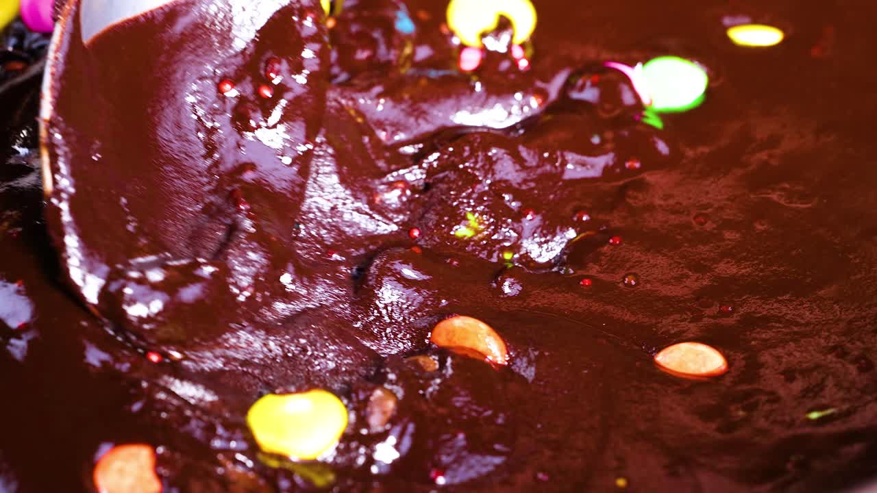 Mixing chocolate and candies with a spoon