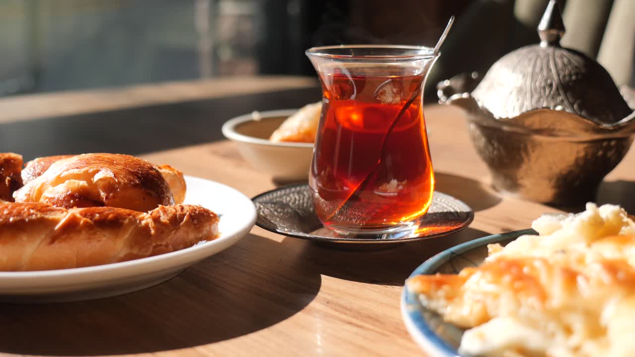 A table with tea, pastry and other foods