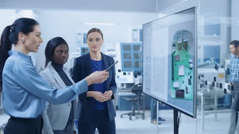 desarrollador de conceptos, ingeniero informático y gerente de proyecto utilizan una pizarra digital interactiva que muestra el concepto de placa de circuitos impresos en 3d. los desarrolladores encuentran la solución al problema. sala de reuniones de fábrica moderna