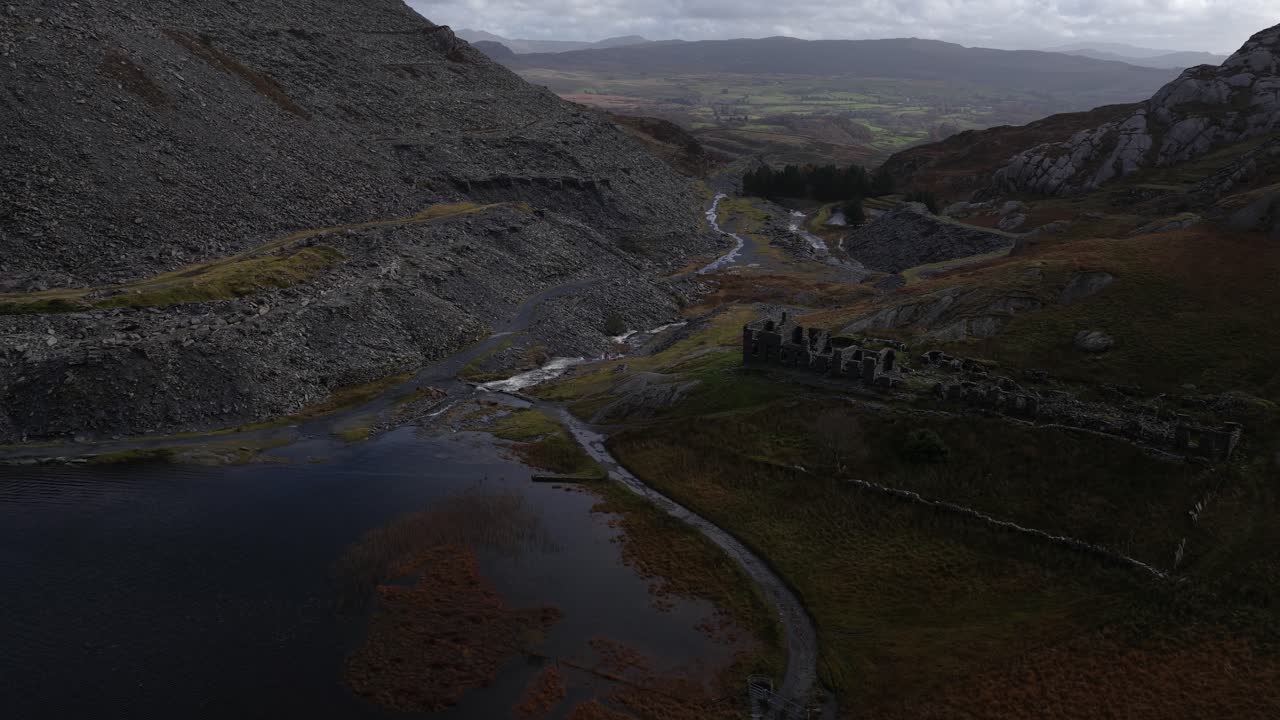 Aerial drone footage of Llyn Cwmorthin and the Moelwyn Mawr range in Eryri National Park, capturing serene lakeside scenery, dramatic Welsh mountains, and the region’s slate-mining heritage