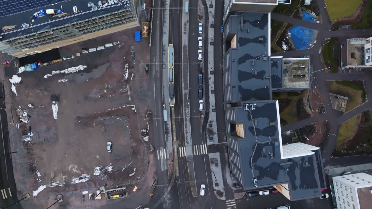 Top down drone shot following a lightrail on the streets of Helsinki, winter day