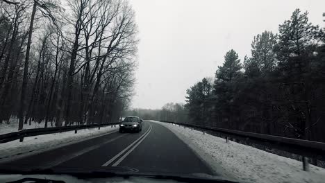 POV-vehicle-drive-countryside-wet-road-winter-scenery-snow-forest-bare-trees-dirty-window-gopro-point-of-view-car-travel-cloudy-sky