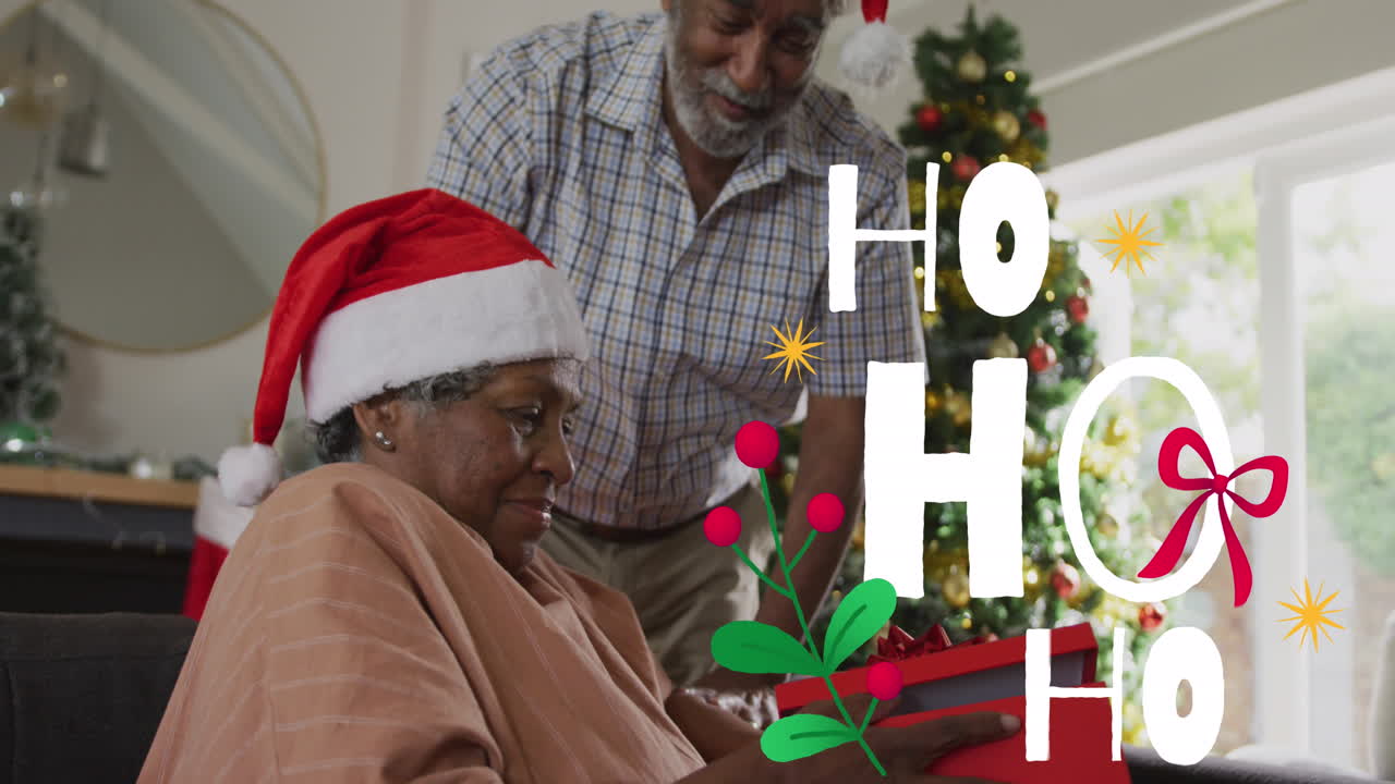 Animasi teks 'ho ho ho' di atas pasangan Afrika-Amerika senior mengenakan topi Santa