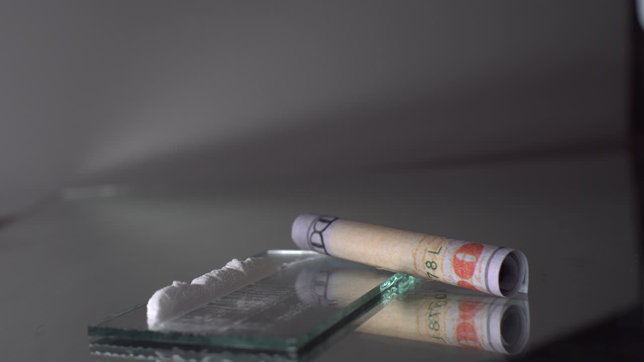 마약과 돈은 극적이고 영화적인 장면에서 항목 위에 두 번 빛을 비추는 클로즈업