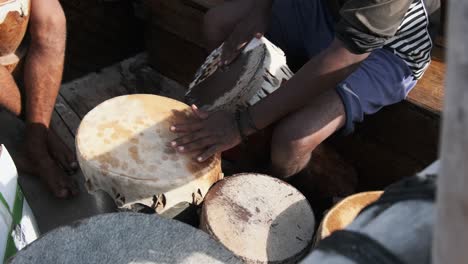 group of local africans playing drums on traditional dhow boat at trip, zanzibar