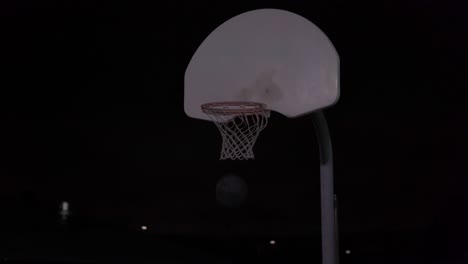 Una-Adolescente-Regatea-El-Baloncesto-Y-Luego-Lo-Tira-En-La-Red-En-Una-Cancha-Al-Aire-Libre-Por-La-Noche