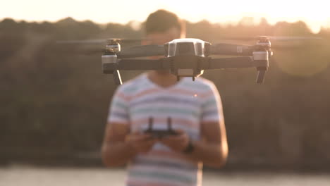 man controlling a drone at sunset