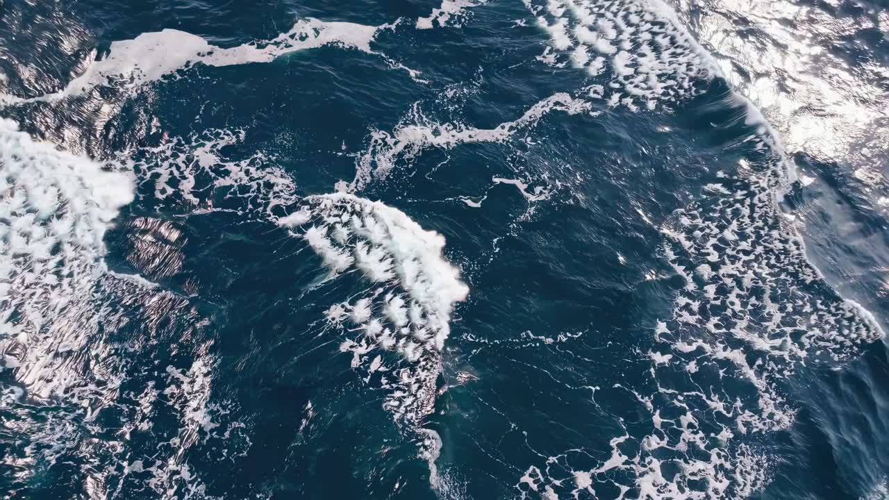 Aerial video captures the vast ocean surface with gentle waves and sunlight reflections