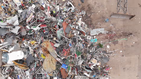 discarded recyclable household appliances pushed onto pile by dozer, top aerial